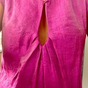 Short pink dress, short sleeves, has a drop shaped cut out at chest.